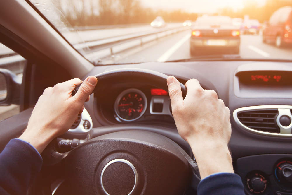 Hände am Steuer im Verkehr - bildlich für Verkehrsrecht